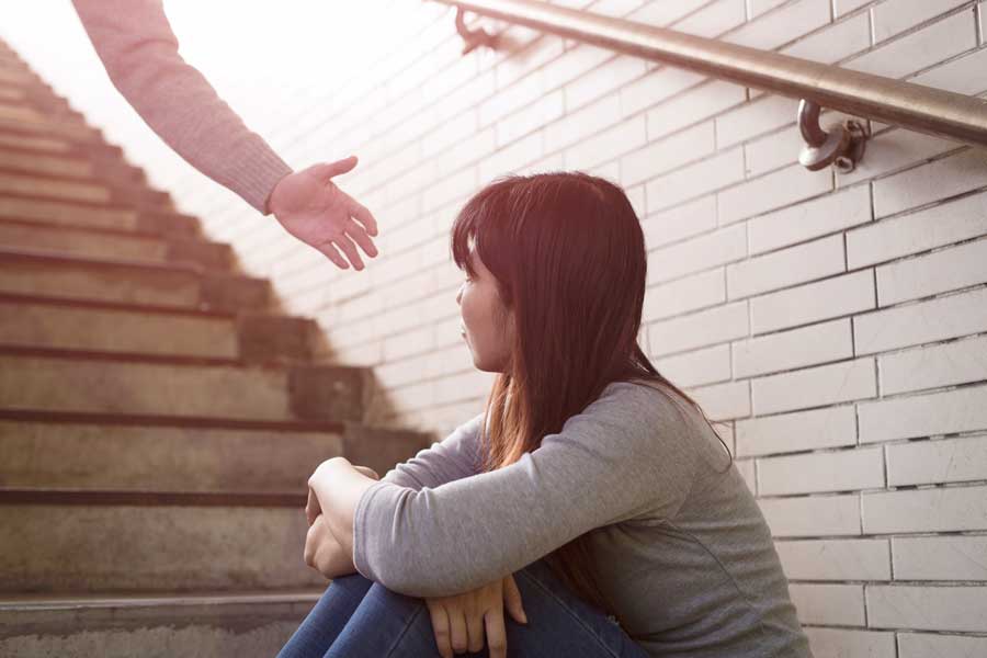 hand reaching out to help female in stairwell