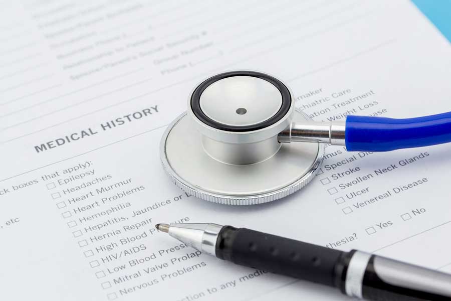 Stethescope and pen placed on generic medical history document