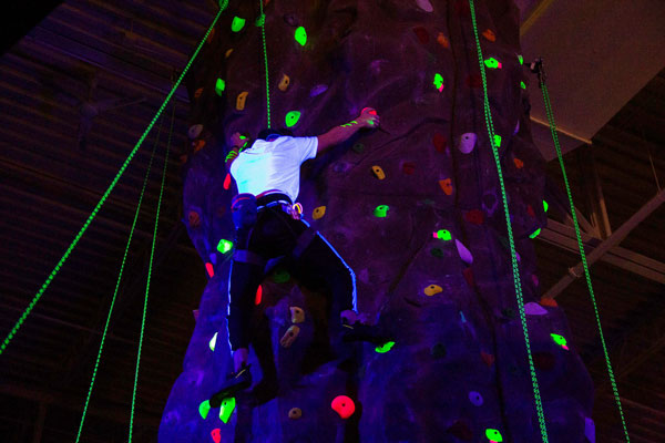 Student climbing rock wall