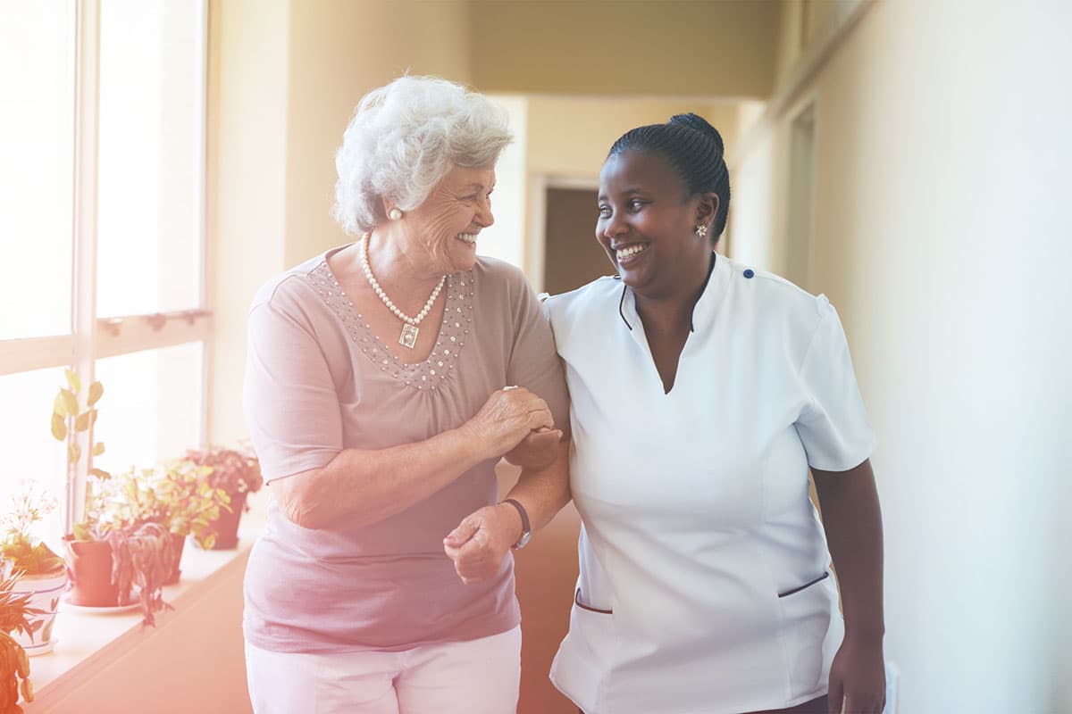 Caregiver and patient walking down a hallway