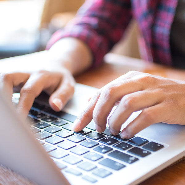 student typing on laptop