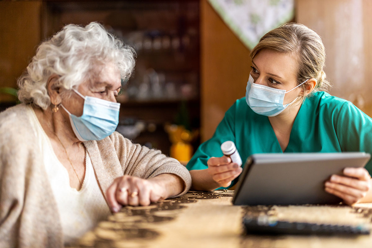 Nurse reviewing prescriptions with elderly adult