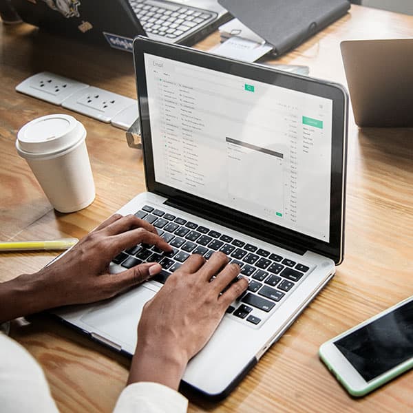 person's hands on a keyboard typing an email