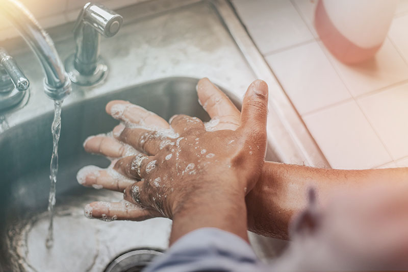 Person washing hands with soap and water