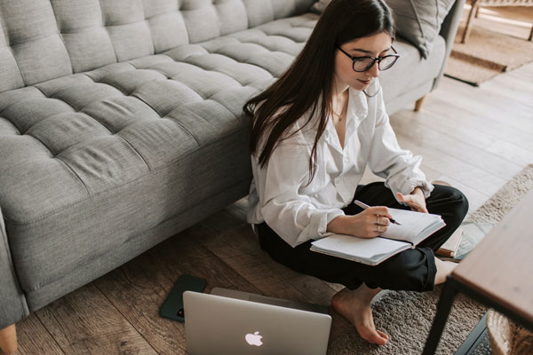 Student sitting on the floor while using laptop