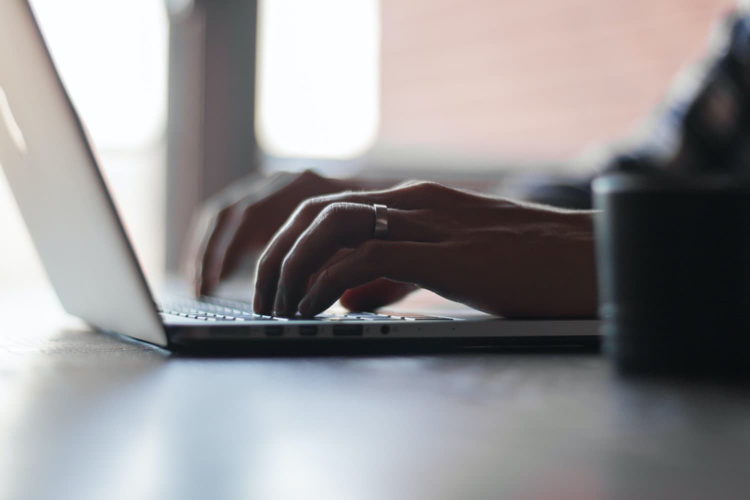 Closeup hands using a laptop keyboard