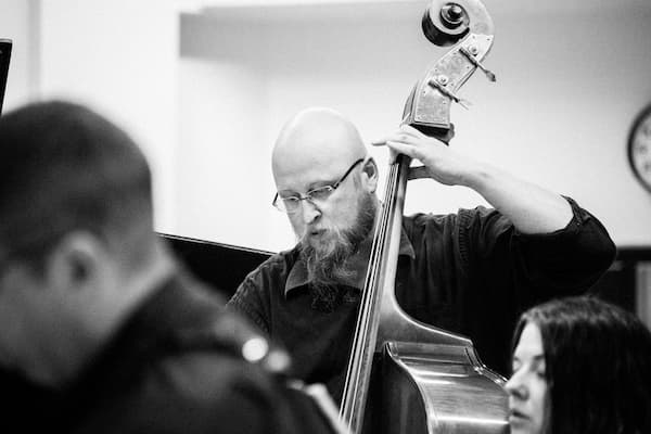 Black and white photo of Michael Dewhirst playing the upright bass