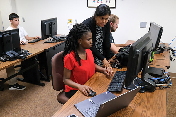 Professor working with student at computer