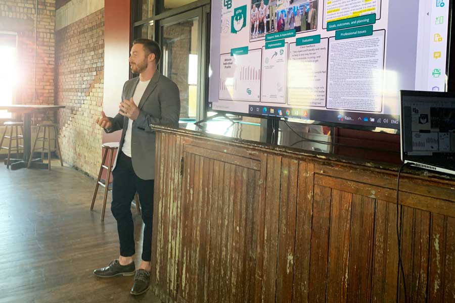 Student presents thesis to peers at end of year gathering