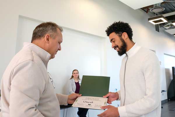 African American male student recieve award at Title Town Tech business pitch competition