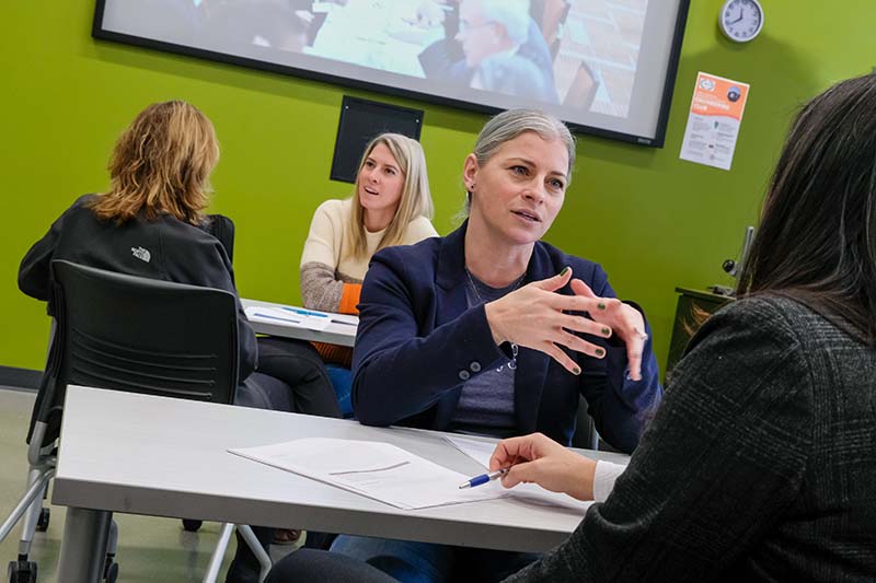 women in classroom working in small groups