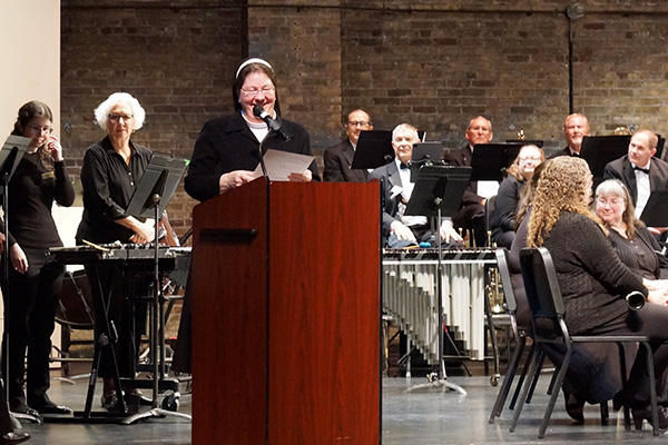 Holy Family Sister speaking at podium on concert stage
