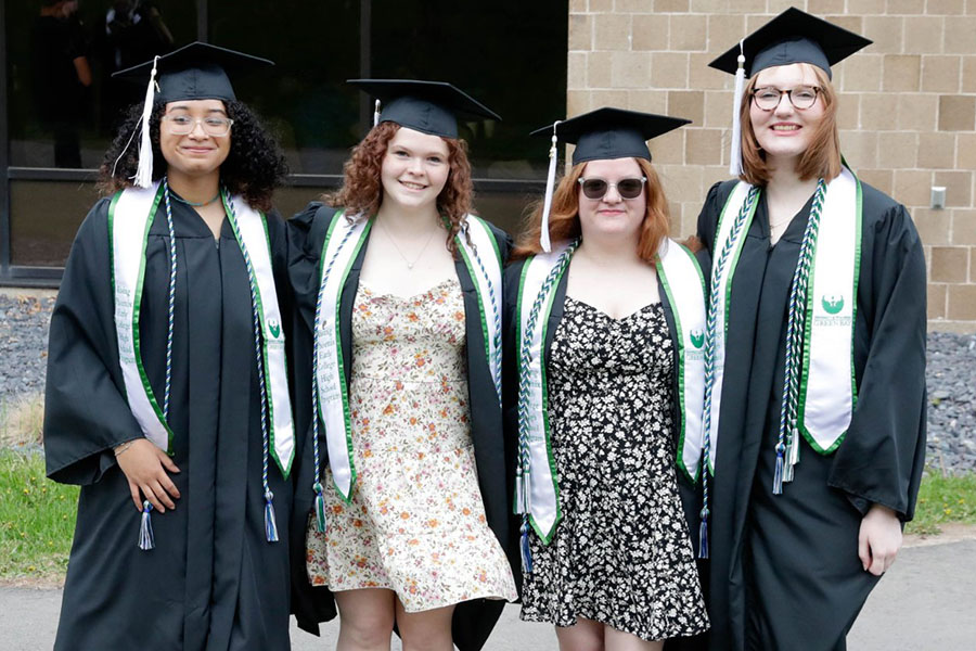 Four female students posing in graduation caps and gowns