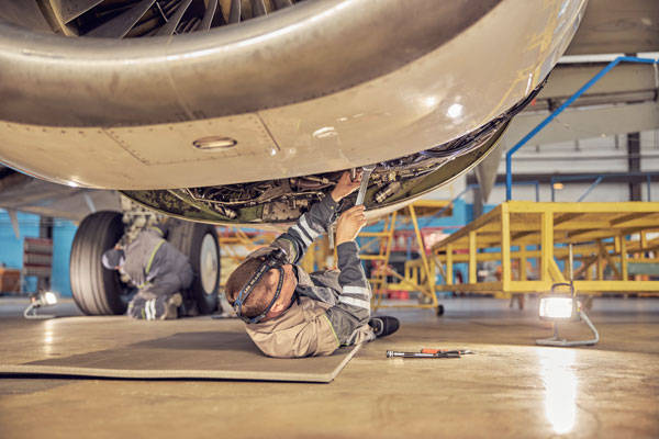 Avionic equipment mechanic works under aircraft