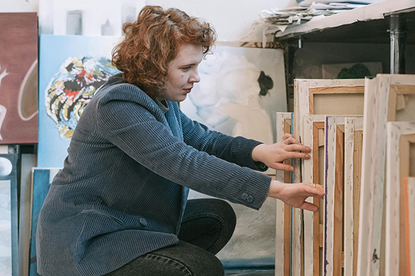 Woman going through art canvases
