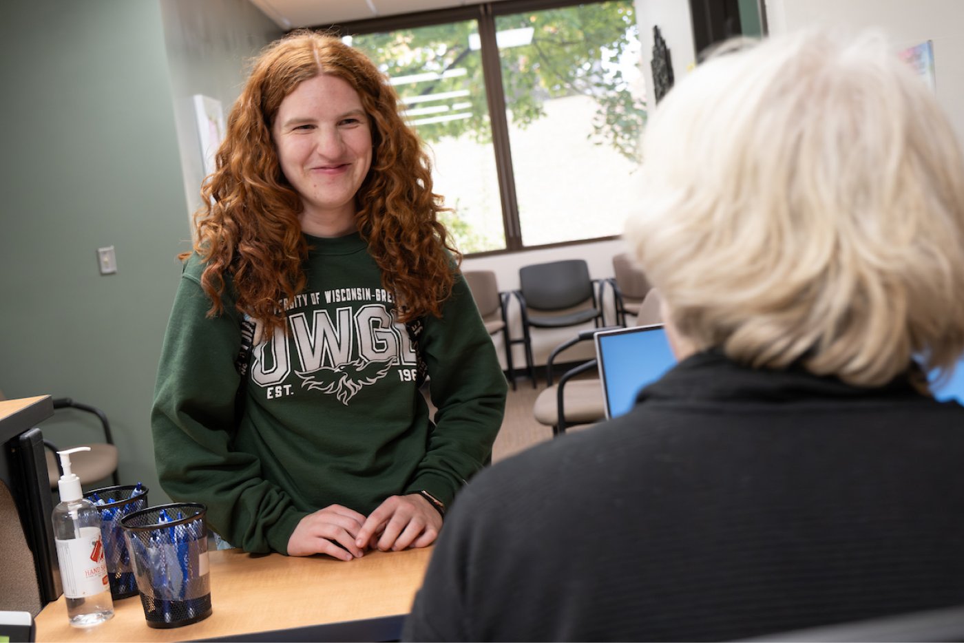 A female student checks in at the Wellness Center front desk