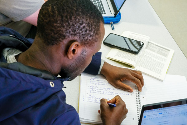 African American student taking notes in class