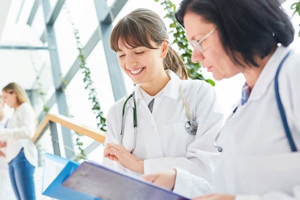 Two healthcare workers look over documents