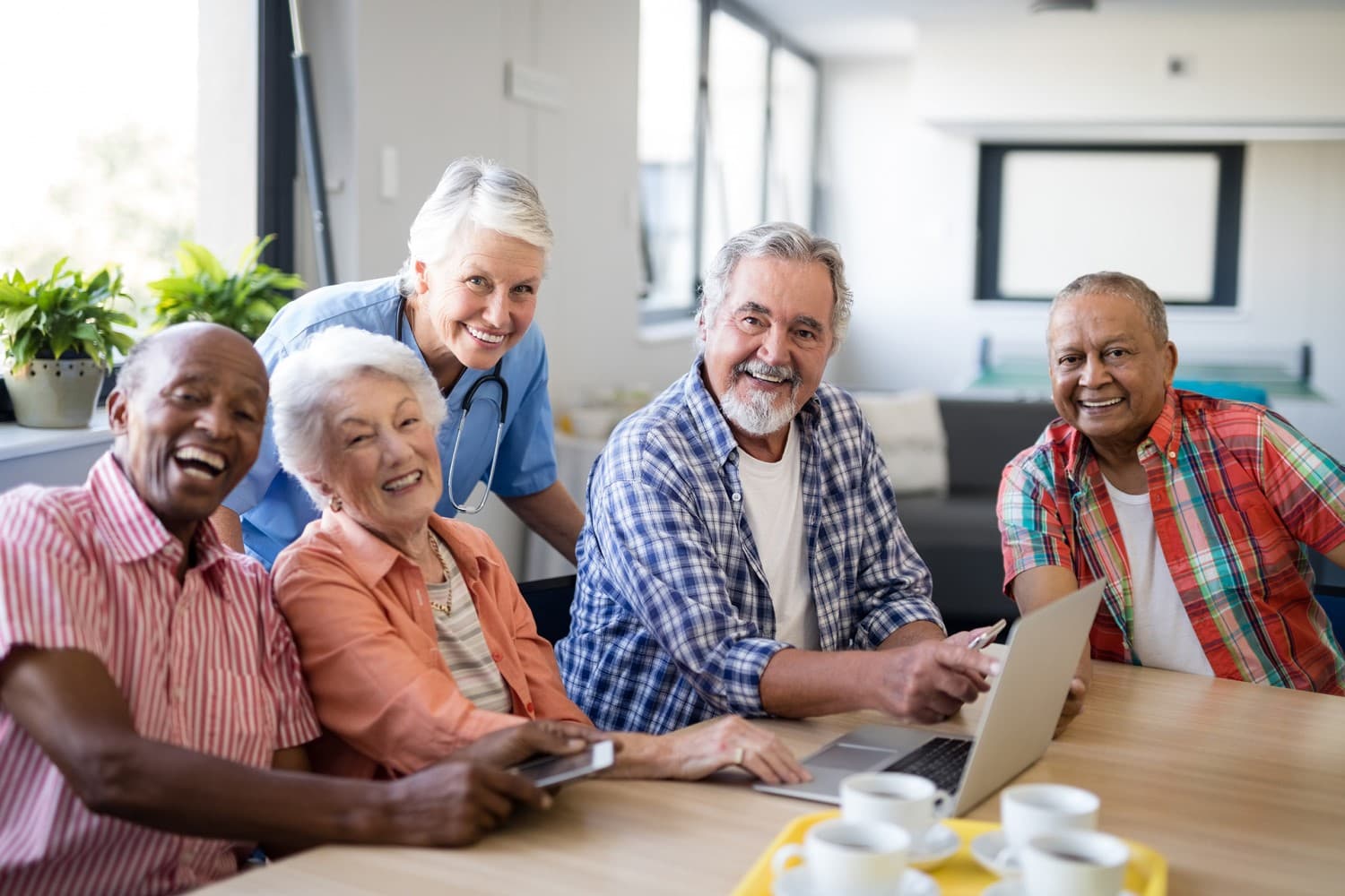 senior adults sitting together at table with laptop