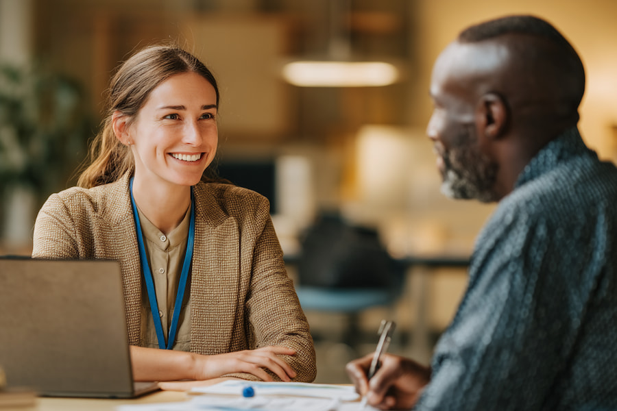 A care coordinator meeting with a client at a table in a professional office setting