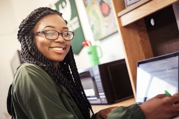 Female student of color studies at desk