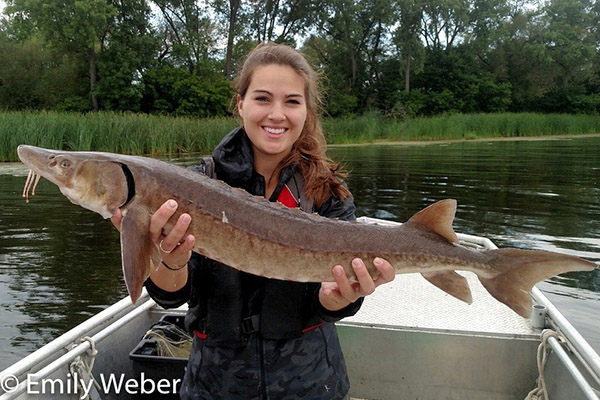 Woman in boat holding Lake Sturgeon