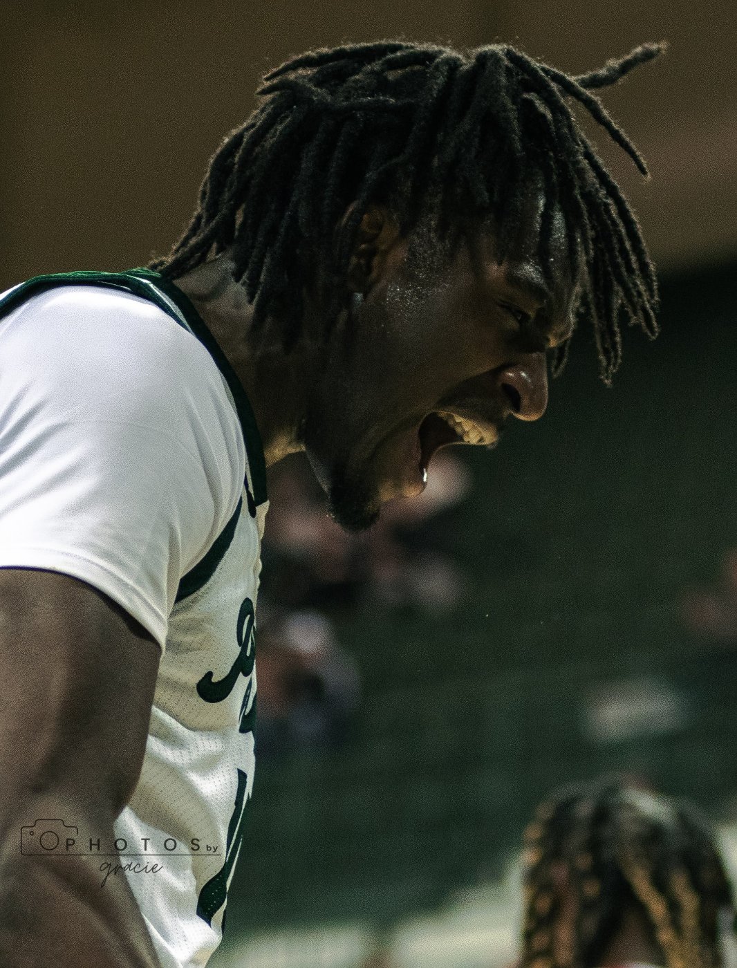 UWGB basketball player grimaces from exertion on the court.