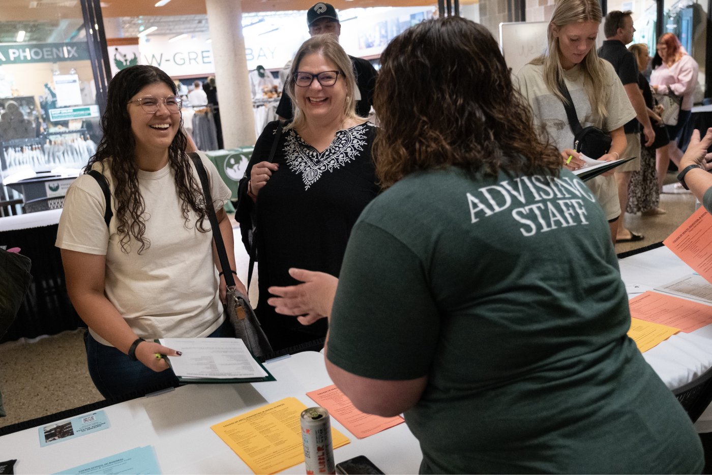 A student and their parent speak with an Advising staff member at GB Orientation