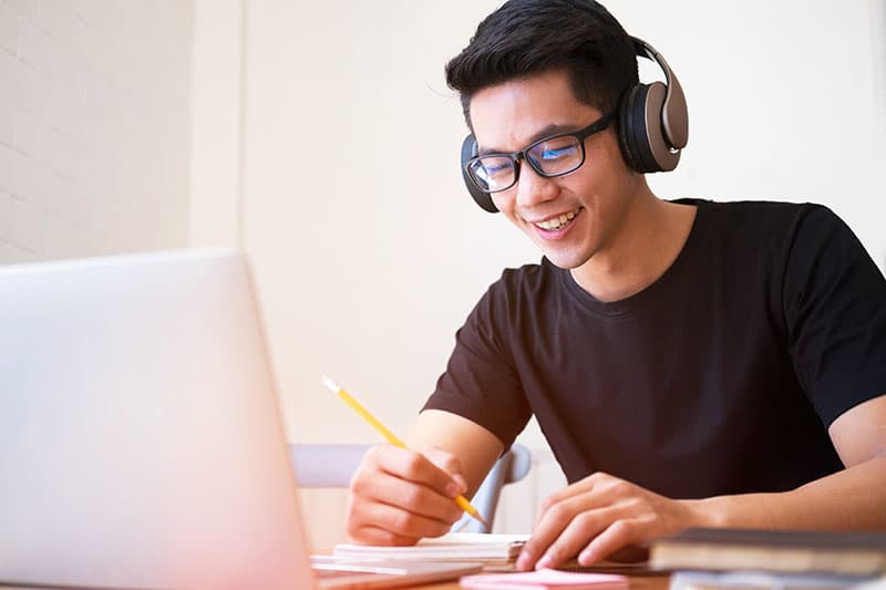 Student wearing headphones using laptop