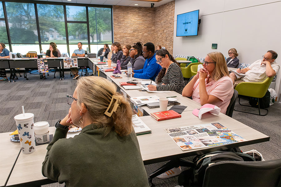 UWGB Applied Leadership Ed.D. students seated in a U-shaped table configuration taking notes during a leadership Q&A session at UW-Green Bay's summer immersion week.