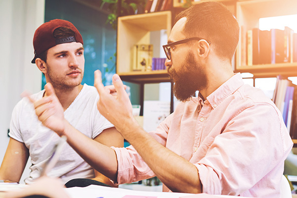 Two men in discussion at a desk