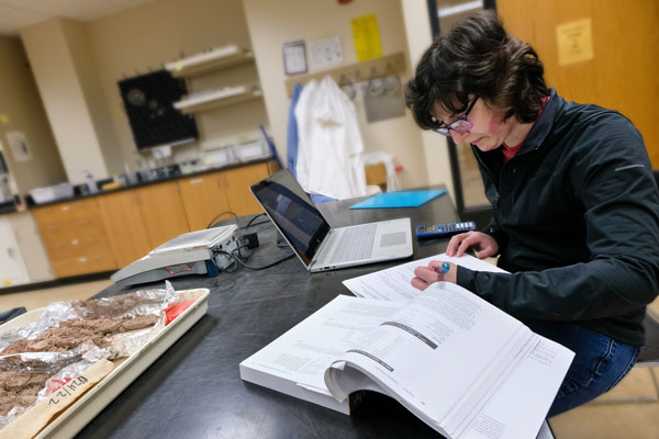 Student reading textbook in lab