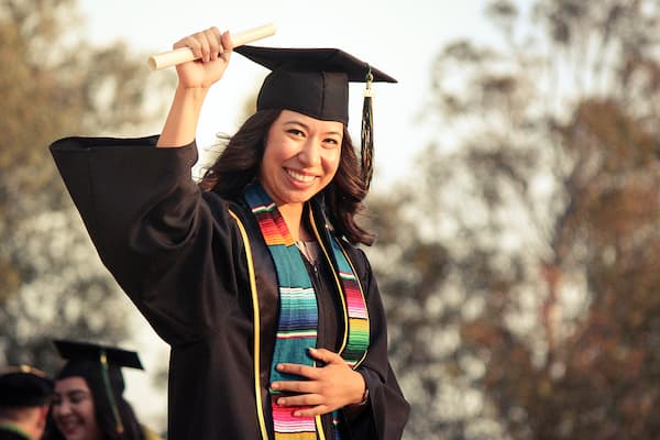 Student raises diploma in the air