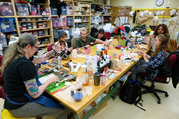 Group of students work on theatre make up in the Costume Shop