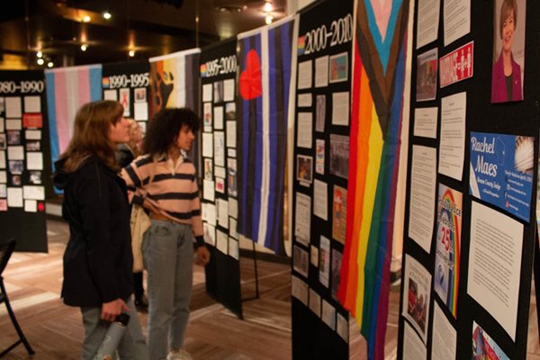 Two students viewing projects displayed at pride event