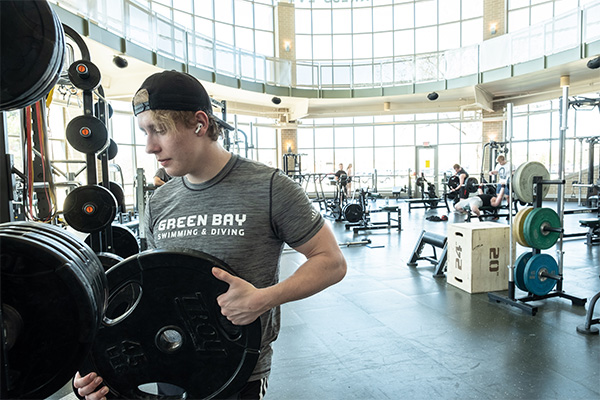 Student using free weights on the weight training floor