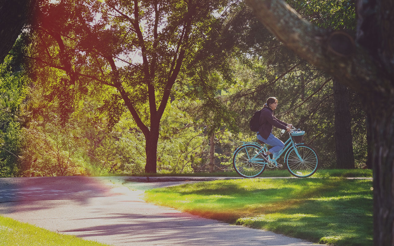 Student riding bike on UW-Green Bay campus