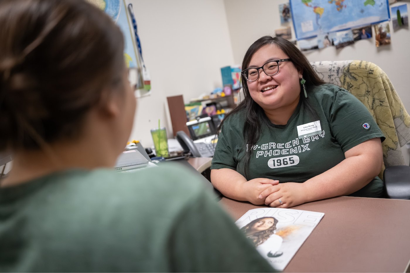 A student in the foreground meets with an Admissions advisor
