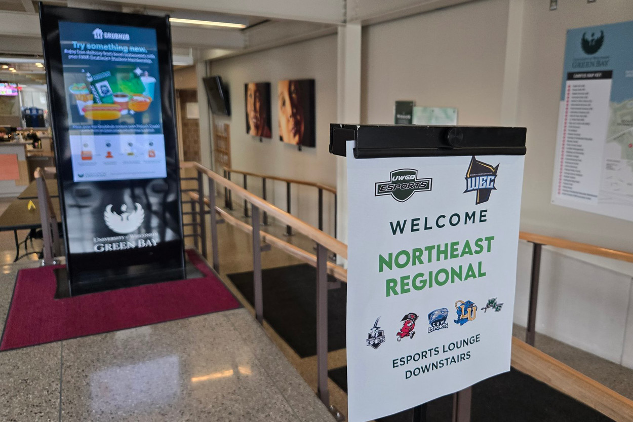 A sign reads "Welcome Northeast Regional. Esports Lounge downstairs" followed by various game logos.
