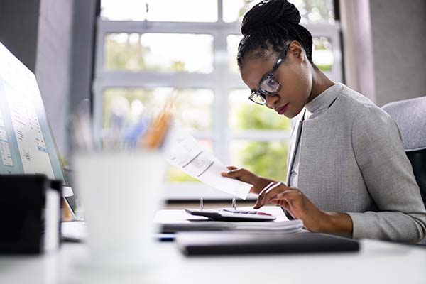 woman using calculator at desk