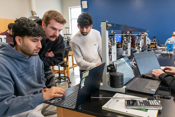 Engineering students run a beam bending metal experiment during Mechanics of Materials Lab in the STEM Innovation Center.