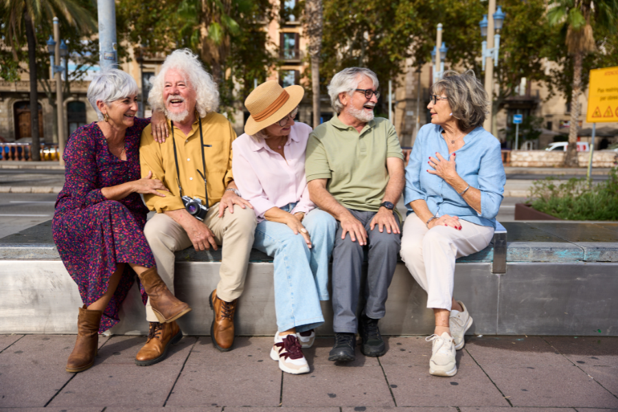 An image of older adults sitting and talking together outside