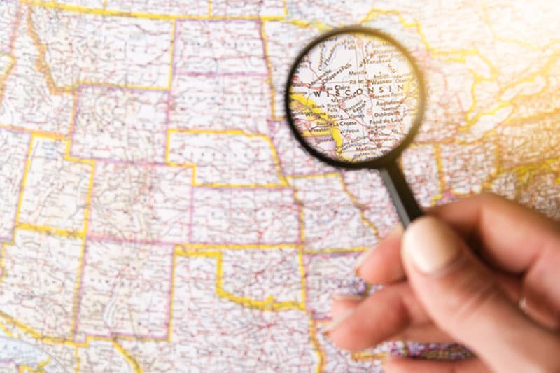 Map of Wisconsin with hand holding magnifying glass