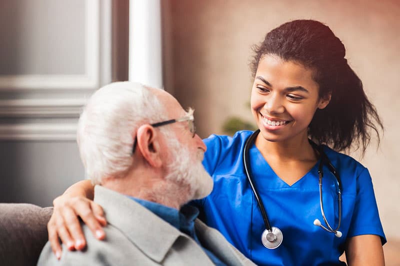 Caregiver comforting and supporting older man