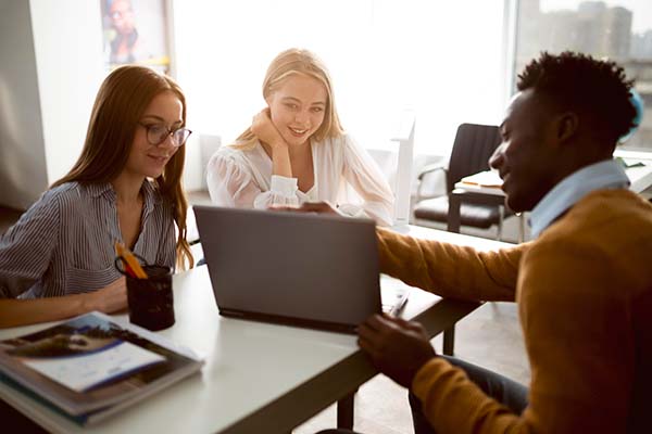 three people meeting looking at laptop during training