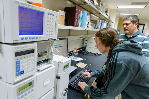 Student and professor work with lab equipment