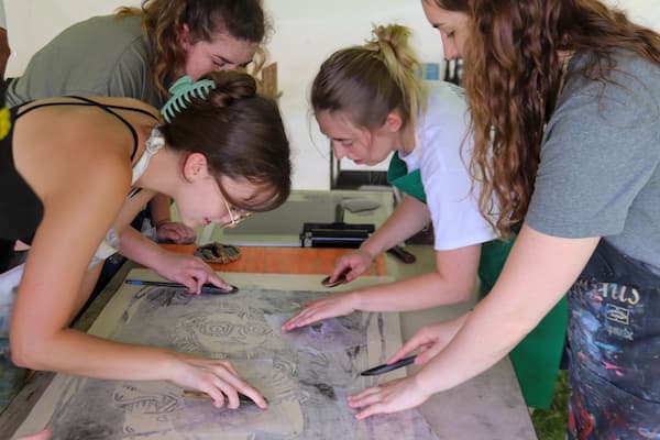 Group of students work on large print together