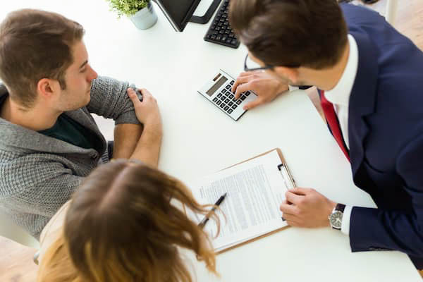 Male accountant meets with a young couple, clients