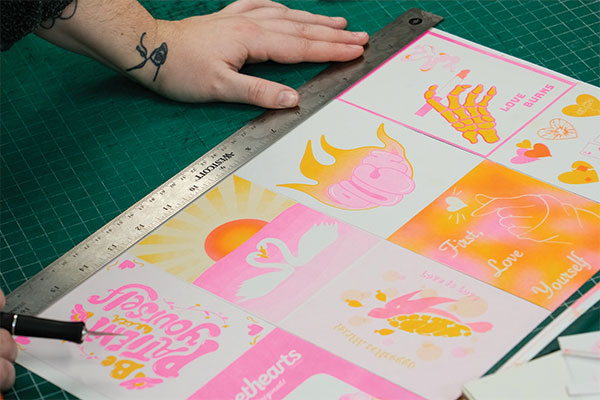 Students cutting out Valentines from a Risograph printer.