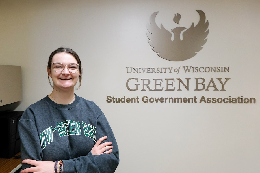 Student in front of the SGA wall sign